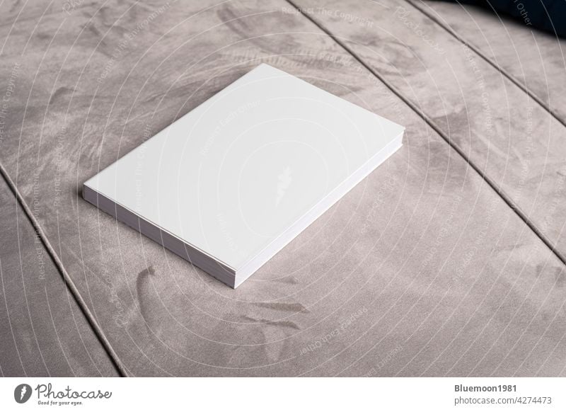 Buch mit leerem Einband auf grauem Samt-Sofa-Hintergrund Attrappe editierbar Wandel & Veränderung blanko Vorlage realistisch schwarz Taschenbuch Werbung