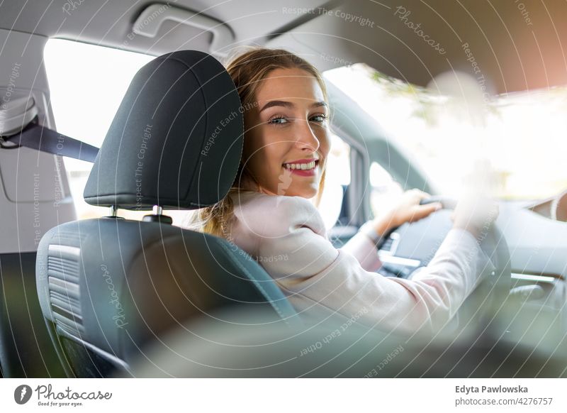 Junge Frau am Steuer eines Autos Carsharing selbstbewusst Lächeln Befriedigung attraktiv schön junger Erwachsener Freude positiv Inhalt Sitzen Fahrer Besitzer