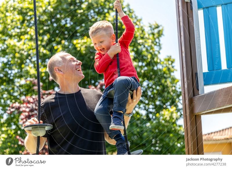 Vater spielt mit seinem 3 Jahre alten Sohn auf dem Spielplatz Spaß Kind Kleinkind Kinder Porträt Natur Lachen Bonden Zusammengehörigkeitsgefühl Elternschaft