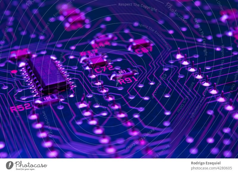 Elektronische Platine Komponenten Chips Widerstände beleuchtet mit Neon-Licht Hintergrund blau Holzplatte Kondensator Postkarte Schaltkreis Nahaufnahme