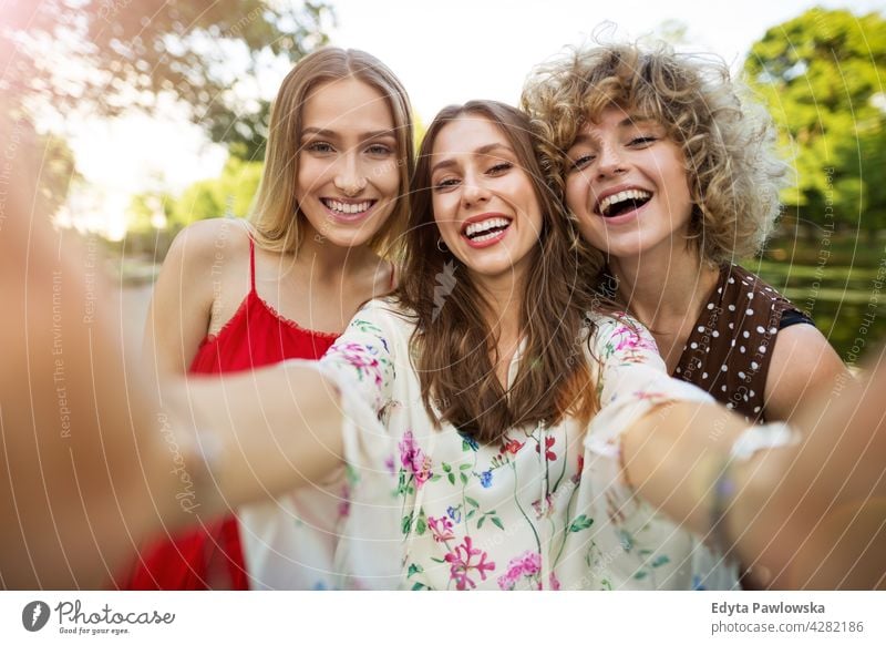 Drei Freunde machen Selfies Sonnenuntergang Sommer Menschengruppe Zusammensein Frau Frauen jung lässig schön attraktiv Mädchen drei Personen Freundschaft