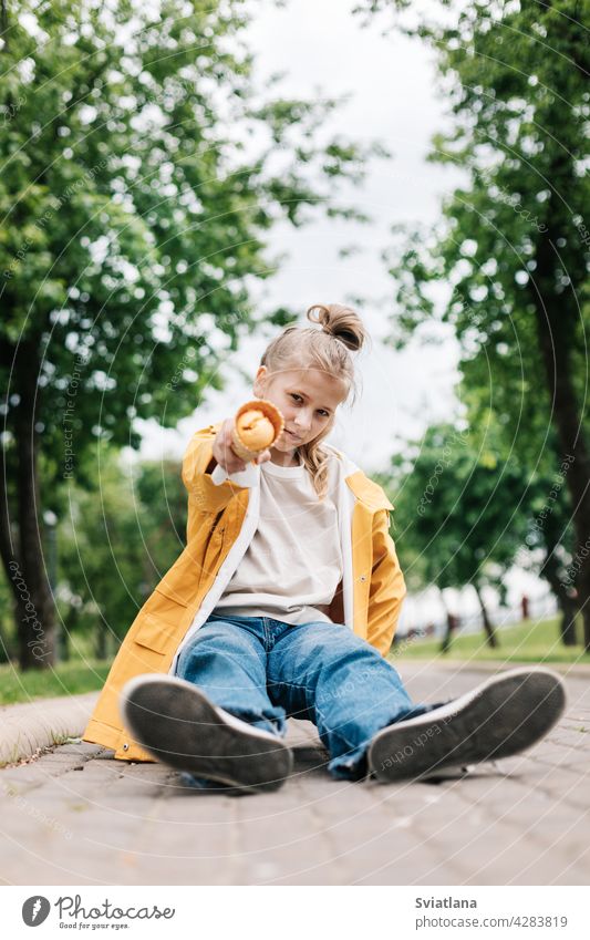 Porträt eines niedlichen blonden Teenager-Mädchens mit Eis bei einem Spaziergang im Park. Kind im Freien Sommer Speiseeis gelb lustig Stilrichtung Spaß Glück