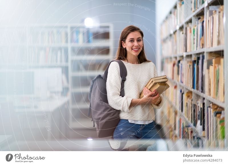 Junge Studentin in einer Universitätsbibliothek genießend Lifestyle jung Erwachsener Menschen eine Person lässig Kaukasier positiv Glück Lächeln Frau attraktiv