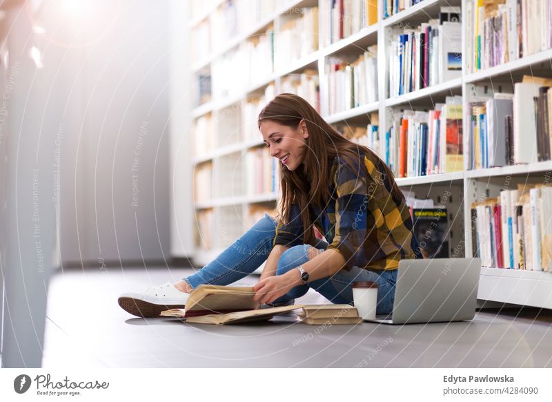 Junge Studentin in einer Universitätsbibliothek genießend Lifestyle jung Erwachsener Menschen eine Person lässig Kaukasier positiv Glück Lächeln Frau attraktiv