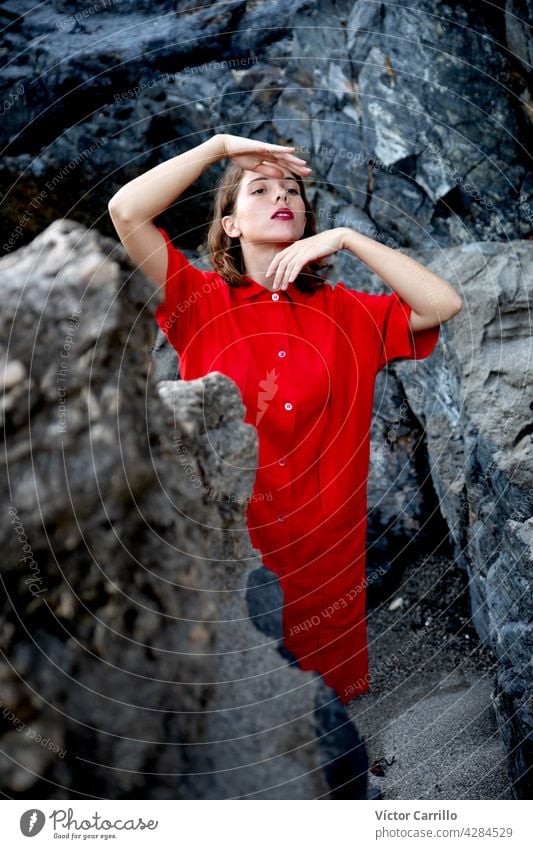 Eine elegante modische frische schöne Frau in einem roten Vintage-Kleid mit Felsen Hintergrund. Porträt Schönheit jung Mode Model Behaarung Gesicht Person