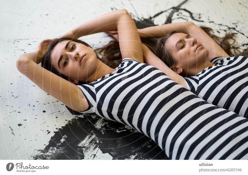 zwei sexy junge Frauen Schwestern Freundinnen in schwarz-weiß gestreiften Kleid liegen auf dem Boden gemalt Künstler Freundschaft Kameradschaftlichkeit Freunde