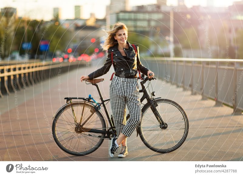 Attraktive junge Frau steht mit ihrem Fahrrad in der Stadt genießend Lifestyle Erwachsener Menschen lässig Kaukasier positiv Glück Lächeln attraktiv schön Tag