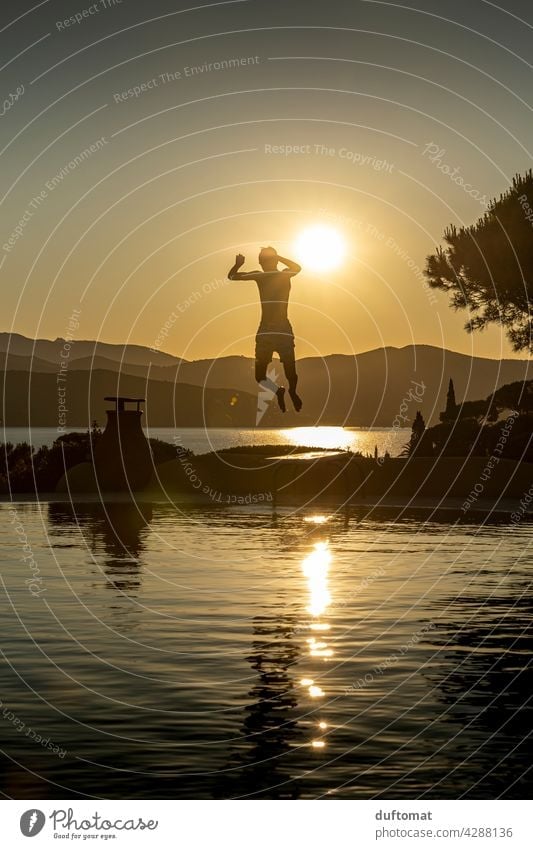 Teenager springt abends von Sprungbrett ins Wasser Abend Sonnenuntergang Pool Junge Gegenlicht Gegenlichtaufnahme Schwimmbad Schwimmen & Baden Freizeit & Hobby