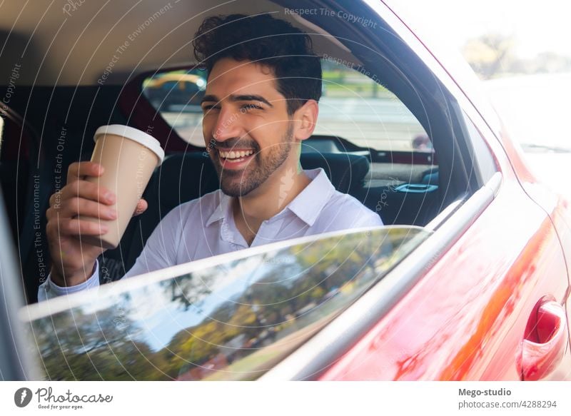 Geschäftsmann trinkt Kaffee im Auto. Mann PKW reisen Lifestyle Taxi professionell Transport Fahrzeug Rücksitz Nahaufnahme zum Mitnehmen stylisch elegant jung