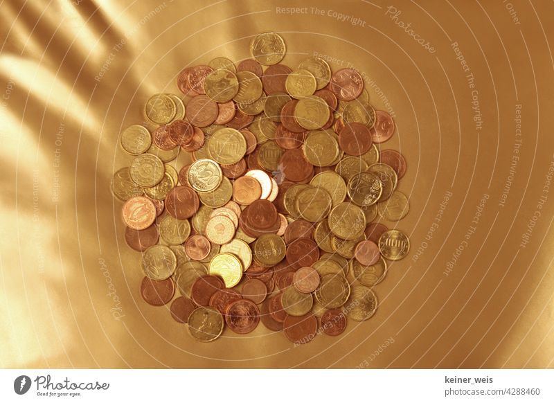 Viele Euro-Cent-Münzen auf einem goldenen Hintergrund - finanzielles Polster aus einem Haufen Kleingeld Geld Cents Geldmünzen bezahlen Kapitalwirtschaft