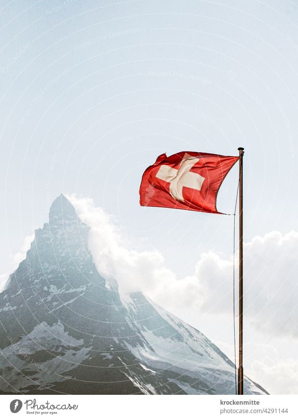 Schweizer Flagge im Wind vor Matterhorn Fahnenmast Nationalflagge Patriotismus wehen Himmel flattern Stolz Wolken blau Außenaufnahme rot Zermatt Wahrzeichen