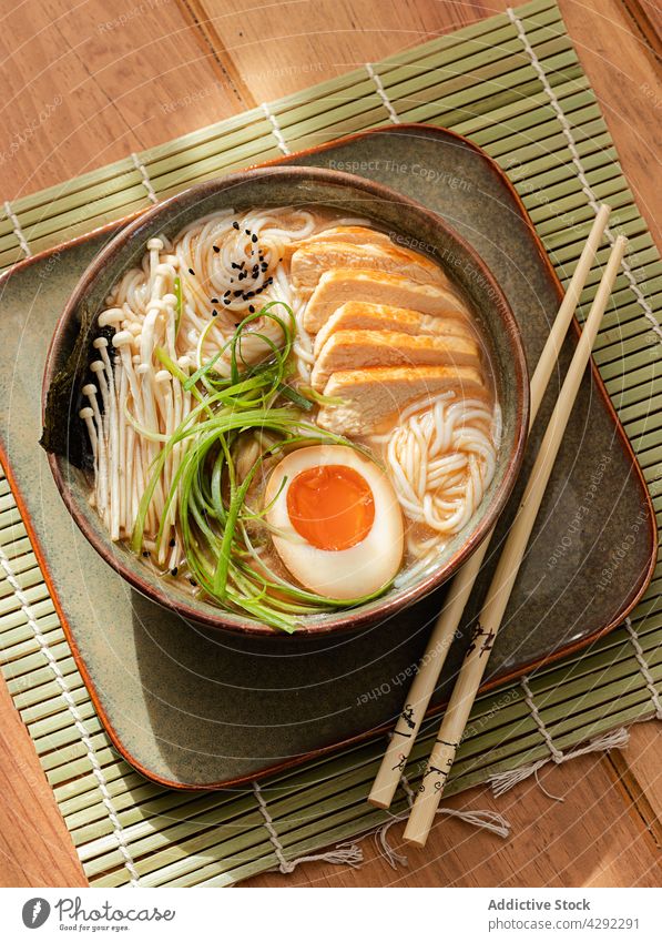 Ramen-Hühnersuppe in einer Schüssel mit Stäbchen Küche Bohnenkraut Fleisch Frühlingszwiebel Asien selbstgemacht Miso mariniert Japanisches Essen Tisch hell Udon