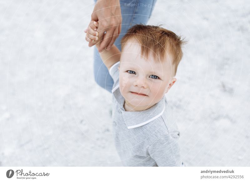 Porträt eines niedlichen kleinen Jungen auf dem Hintergrund von weißem Sand in der Natur. Glückliches Gesicht ist nah. Familie Spaß Kind Menschen Vater