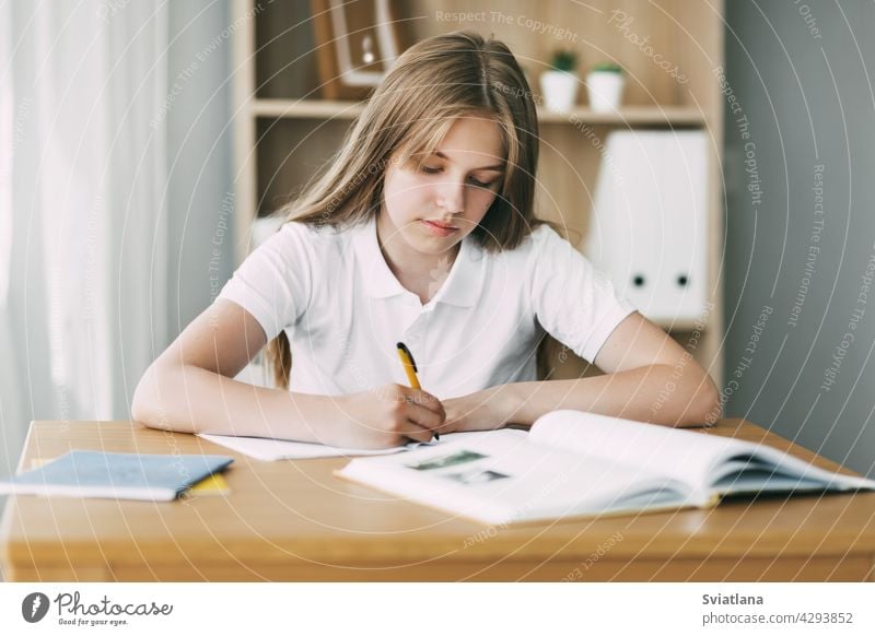 Ein Gymnasiast macht sich Notizen aus einem Buch, ein Teenager-Mädchen macht ihre Hausaufgaben und bereitet sich auf den Unterricht vor. Bildung, Ausbildung, Hausaufgaben