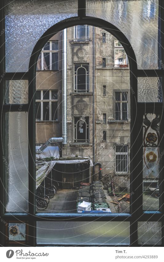 Blick durch das alte Treppenhausfenster auf den Hinterhof Friedrichshain Fenster Berlin Altbau unsaniert Trzoska window Haus Menschenleer Stadt Stadtzentrum