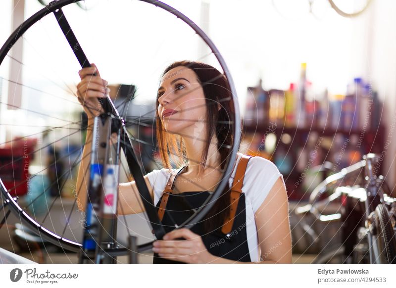 Junge Frau arbeitet in einer Fahrradwerkstatt Vertriebsmitarbeiter Fahrradmechaniker Radfahren Fahrradladen Business Einzelhandel Zyklus hilfreich