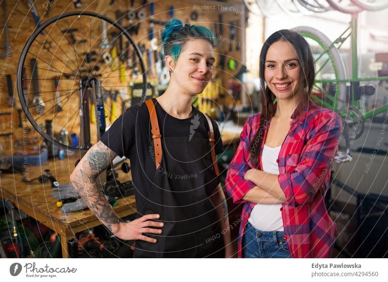 Zwei junge Frauen arbeiten in einer Fahrradwerkstatt Vertriebsmitarbeiter Fahrradmechaniker Radfahren Fahrradladen Business Einzelhandel Zyklus hilfreich