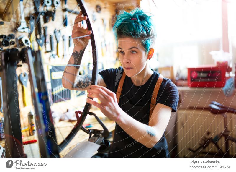 Junge Frau arbeitet in einer Fahrradwerkstatt Vertriebsmitarbeiter Fahrradmechaniker Radfahren Fahrradladen Business Einzelhandel Zyklus hilfreich