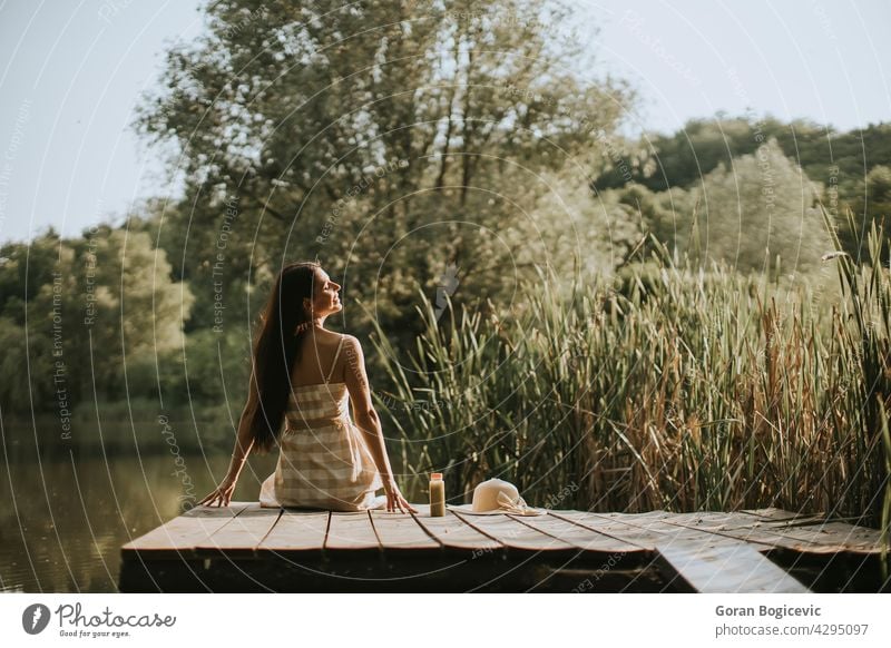 Entspannende junge Frau auf Holzsteg am See schön sorgenfrei lässig Kaukasier Küste Konzept Tag Schiffsdeck träumen genießen gut Glück Anlegestelle Freizeit