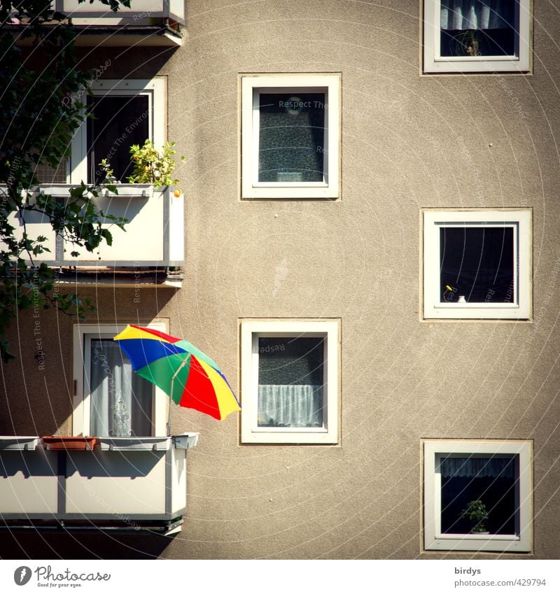 Anarchie Häusliches Leben Haus Balkon Sonnenschirm Plattenbau Fassade leuchten außergewöhnlich Originalität trist mehrfarbig grau Einsamkeit Entschlossenheit