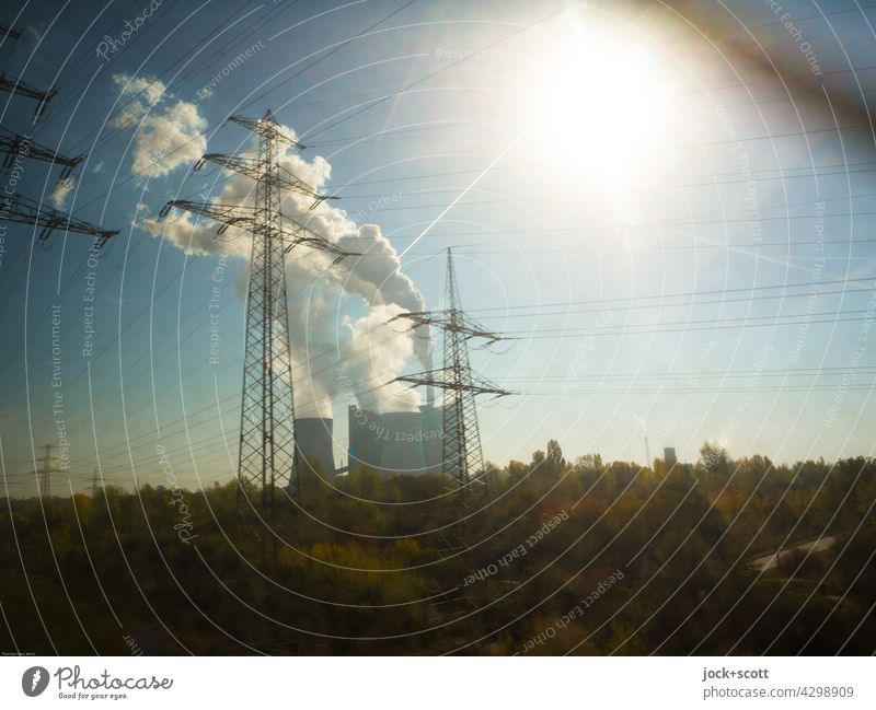 Kraftwerk zieht am fahrenden Zug vorbei Energiewirtschaft Industrie Sonne Wolken Schornstein Umweltverschmutzung Luftverschmutzung Bewegungsunschärfe Strommast