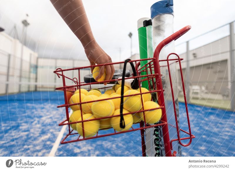 Mann fängt Bälle, um an einem bewölkten Tag mit Paddle-Tennis zu trainieren jung Training Paddeltennis Padel Gericht Sport Ball Remmidemmi Netz im Freien