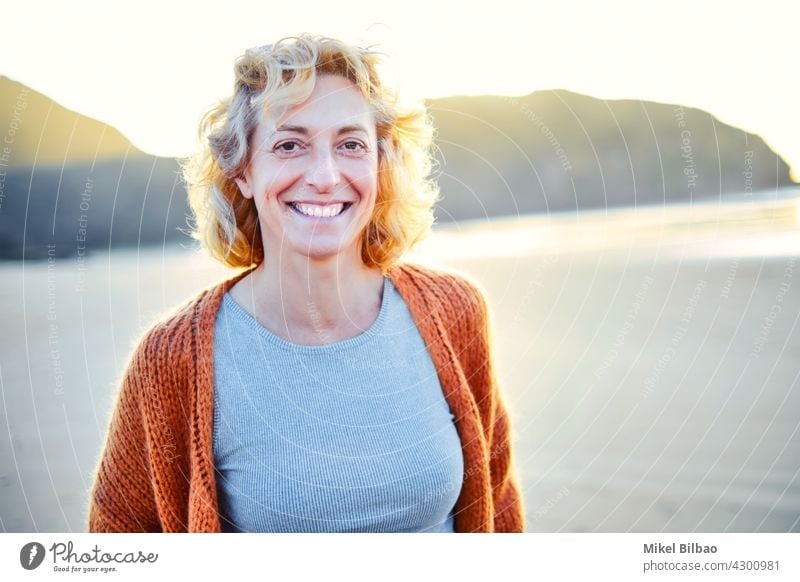 Junge reife blonde kaukasische Frau im Freien in einem Strand in einem sonnigen Tag. Lifestyle-Konzept. Porträt Wellness Frauen Gesundheit Erholung