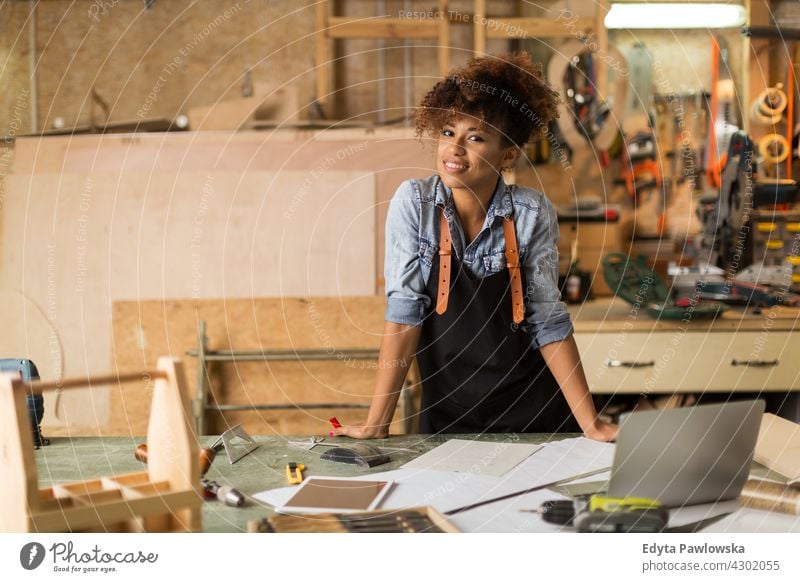 Selbstbewusste junge Frau bei der Arbeit in der Werkstatt Besitzer Beruf Dienst Kleinunternehmen Mitarbeiter arbeiten Techniker Arbeitsplatz Arbeiter