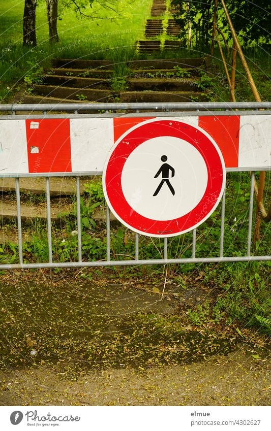 Verkehrszeichen " Verbot für Fußgänger" und rot-weiße Warnbake vor einer langen Treppe in einem Park / VZ 259 / Durchgangsverbot Piktogramm Kreis Eingangsverbot