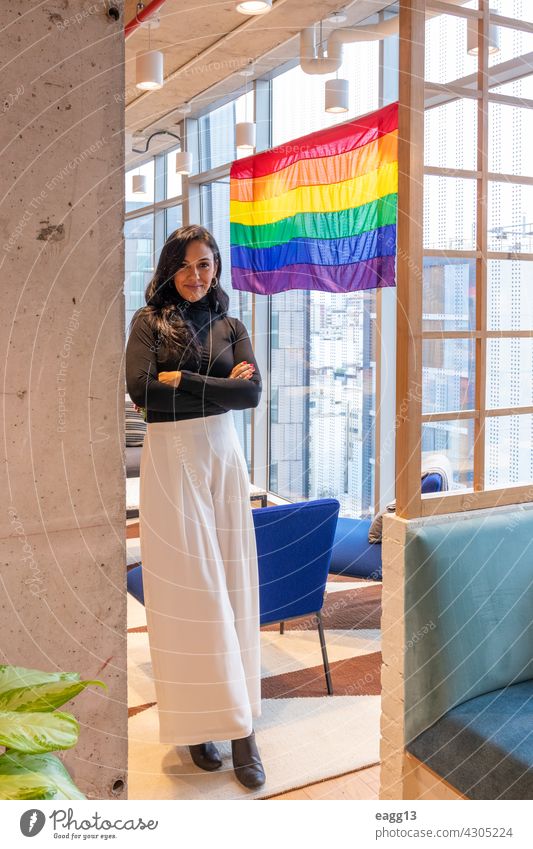 Brünette Frau ist stolz darauf, die LGBT-Gemeinschaft zu repräsentieren lesbisch lgbt Stolz allein Porträt brünett Lifestyle Vielfalt hispanisch bewundern Fahne