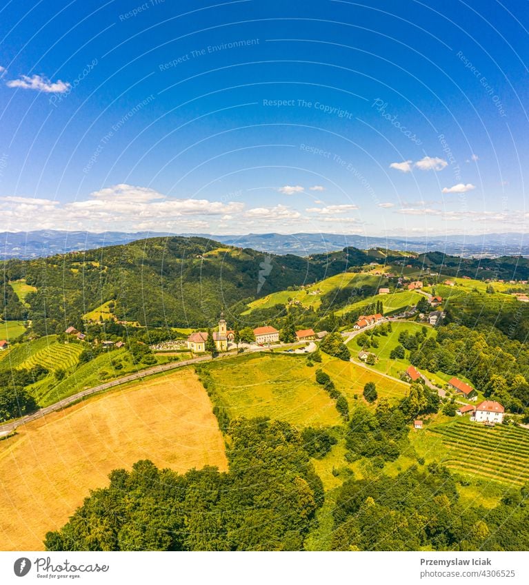 Luftaufnahme von grünen Hügeln und Weinbergen mit Bergen im Hintergrund. Österreich Weinberge Landschaft in Kitzeck im Sausal Sommer Natur Frühling Ackerbau