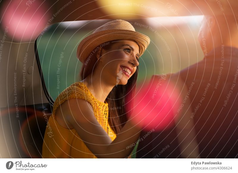 Junges Paar sitzt im Kofferraum ihres Autos und beobachtet den Sonnenuntergang Autokofferraum Lichter Wohnmobil Camping PKW Sommer Feiertag Sonnenaufgang