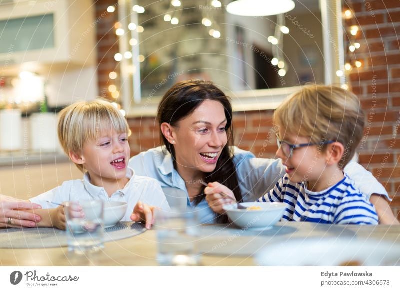 Mutter und Kinder beim Frühstück Familie Eltern Verwandte Partnerschaft Frau Mama Menschen zwei drei Erwachsener Sohn Junge Glück Lifestyle Lächeln Fröhlichkeit