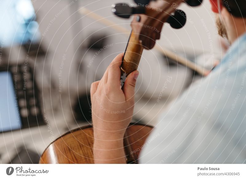 Nahaufnahme Hand hält ein Cello Musik Musiker Musikinstrument Innenaufnahme Farbfoto Saite Konzert Streichinstrumente Orchester Detailaufnahme musizieren Geige
