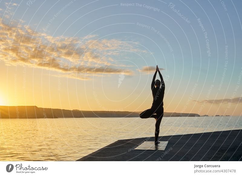 Silhouette der Frau übt Yoga im Gegenlicht jung praktizieren Fitness schlank Training passen Übung Pose Lifestyle Kaukasier positionieren Gesundheit Aktivität