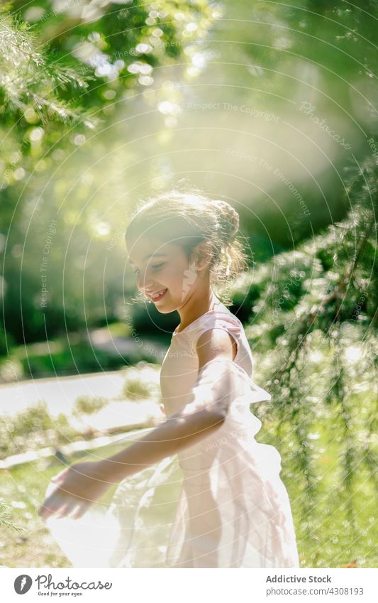 Entzückte Ballerina beim Spielen im Sommerpark Mädchen spielen spielerisch Teenager Balletttänzer Tänzer Glück Tanzen Park Wiese Kleid Freude Natur heiter