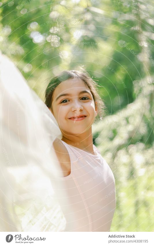 Entzückte Ballerina beim Spielen im Sommerpark Mädchen spielen spielerisch Teenager Balletttänzer Tänzer Glück Park Wiese Kleid Freude spitze Schuh Natur heiter