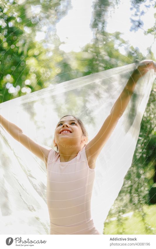 Entzückte Ballerina beim Spielen im Sommerpark Mädchen spielen spielerisch Teenager Balletttänzer Tänzer Glück Tanzen Park Wiese Kleid Freude Natur heiter