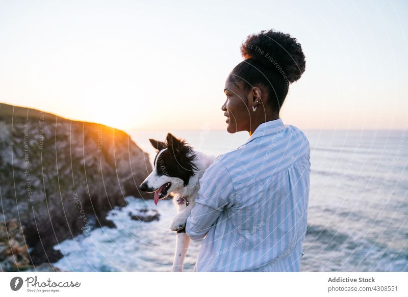 Glückliche schwarze Frau hat Spaß mit Hund am Strand Sonnenuntergang Zusammensein spielen Liebe Besitzer Haustier Tier Begleiter Eckzahn MEER Reinrassig