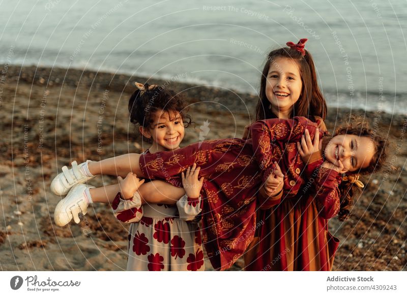 Fröhliche Geschwister haben Spaß am Strand Kind Mädchen Schwester Spaß haben Zusammensein MEER Geschwisterkind Kinder Glück niedlich ethnisch Menschengruppe