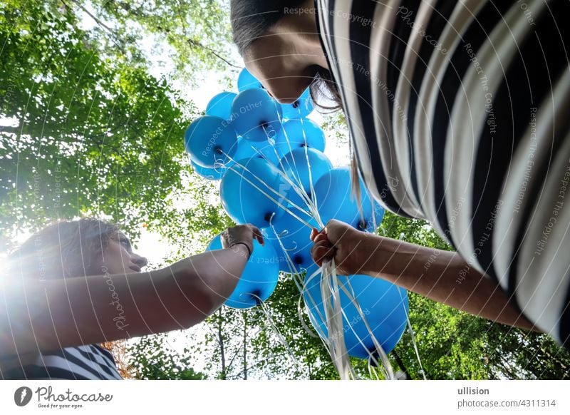 Blick von unten auf 2 blonde Frauen in schwarz-weiß gestreiften Kleinen mit einem Haufen blauer Luftballons Freunde Menschen Spaß Schönheit Erwachsener Ballons