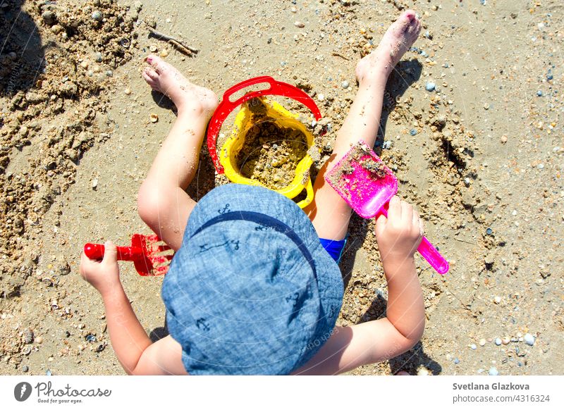 Kind spielt mit Sand, Schaufel, Eimer Strand Baby Burg oder Schloss Sommer wenig Gebäude spielen Kleinkind Urlaub Freude Freizeit Spielzeug Kindheit Sandburg