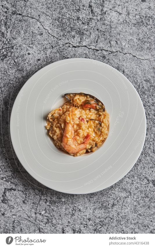 Reis mit Meeresfrüchten auf Teller Paella Speise Restaurant dienen Mahlzeit lecker Küche Lebensmittel geschmackvoll Spanisches Essen spanische Küche Tisch