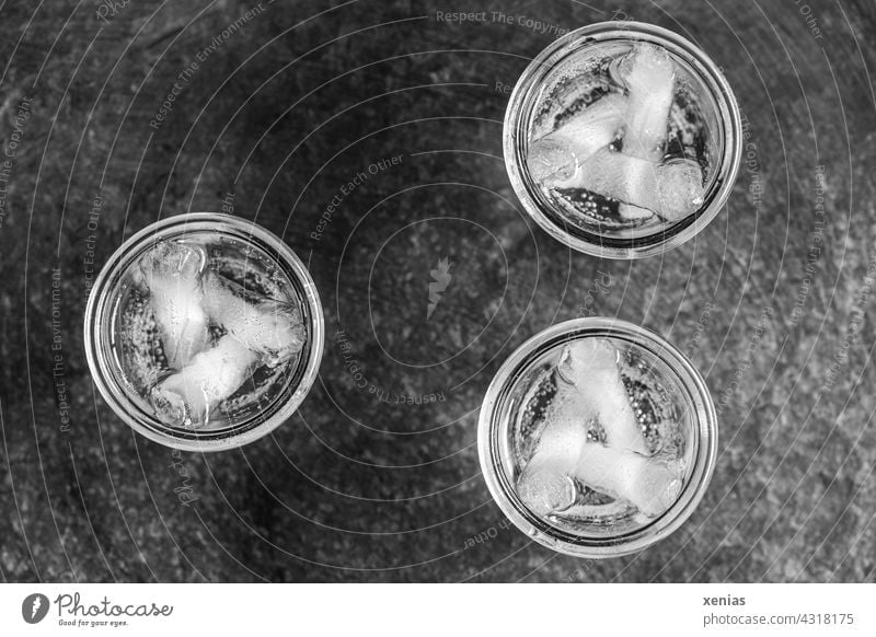 Drei runde Gläser mit Wasser und Eissticks in Schwarz-Weiß trinken drei Glas Getränk Flüssigkeit Trinkwasser Durst Wasserglas Mineralwasser Eiswürfel kalt