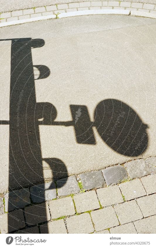 Schatten eines Verkehrszeichens und einer Verkehrsbake auf einem Fußweg / Absperrung / Gefahrenstelle verboten für Fußgänger verboten Absperrgitter Vorschrift