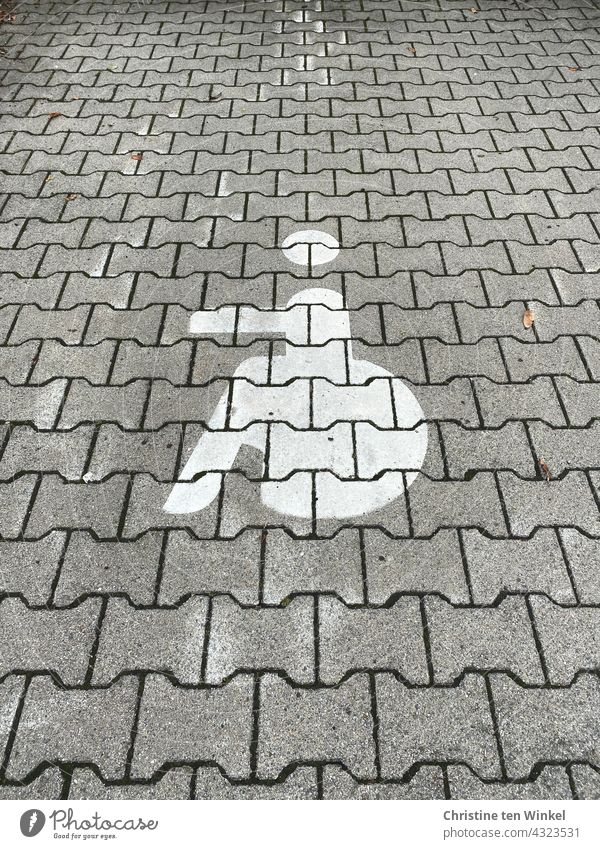 Rollstuhlfahrer Symbol auf einem gepflasterten Parkplatz, Behindertenparkplatz, Gehbehinderung Piktogramm Behindertengerecht Gehbehindert