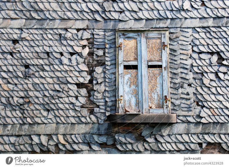 Fensterladen geschlossen mit schiefen wackligen Dachziegeln Haus Architektur Strukturen & Formen Steildach Hintergrundbild Fassade Verfall alt Zahn der Zeit