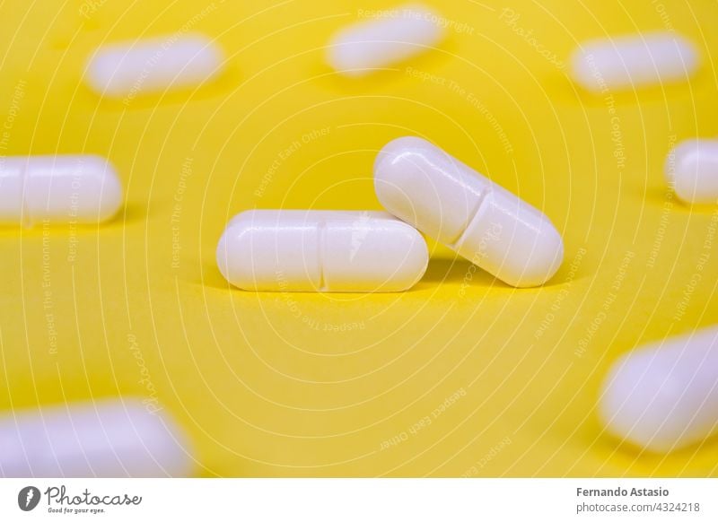 Set von weißen Pillen auf einem gelben Hintergrund. Horizontale Fotografie. Medizin Tablette Kapsel Gesundheit medizinisch Medikament Apotheke Vitamin