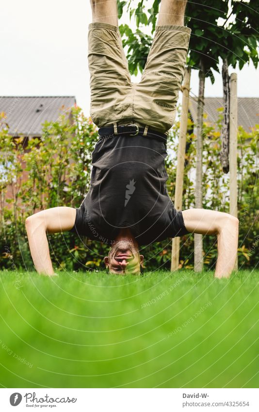 auf dem Kopf - Kopfstand auf der Wiese Mann Handstand Lächeln freude ehrgeizig Leichtigkeit Balance Gleichgewicht disziplin Körperspannung Körperbeherrschung