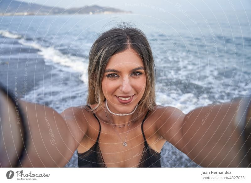 junge Frau nimmt ein Selfie mit dem Handy und das Meer im Hintergrund hübsch Mobile MEER Smartphone Foto Bild Dame Lächeln Nizza Schönheit posierend Telefon